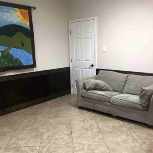 A waiting area at Shady Brook Animal Hospital featuring a painting and a couch